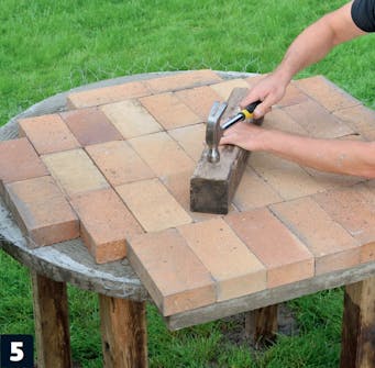 Ujævnheder bankes på plads på muret pizzaovn Ujævnheder bankes på plads bunden af muret pizzaovn